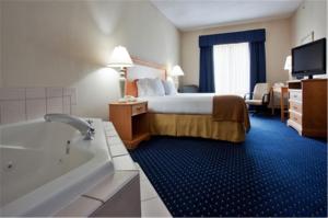 ein Hotelzimmer mit einem Bett und einer Badewanne in der Unterkunft Holiday Inn Express Ashland, an IHG Hotel in Ashland