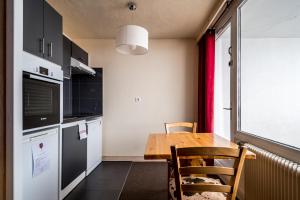 a small kitchen with a wooden table and a window at Résidence Le Portillo in Val Thorens