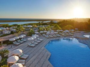 - une vue aérienne sur un complexe avec une piscine et des parasols dans l'établissement Hotel Quinta do Lago, à Quinta do Lago