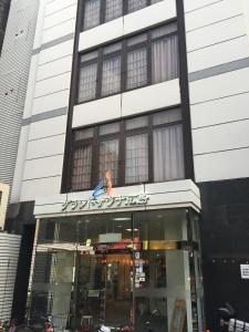 uma loja na frente de um edifício com um sinal nele em Capsule&Spa Grand Sauna Hiroshima (Male Only) em Hiroshima