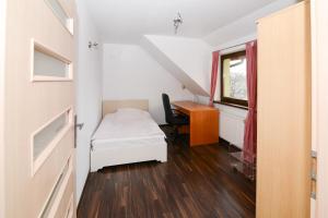 a small room with a bed and a desk at Sweet Family Home in Cieszyn