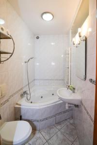 a bathroom with a tub and a sink and a toilet at Sweet Family Home in Cieszyn