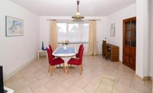 a dining room with a table and red chairs at Sweet Family Home in Cieszyn