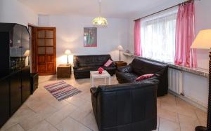 a living room with black leather furniture and pink curtains at Sweet Family Home in Cieszyn