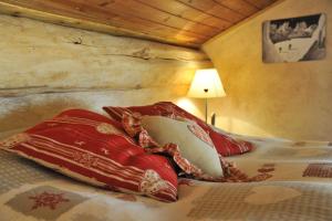 un letto con cuscini rossi sopra di L'Ancien Paquier Chambre D'Hotes a Valtournenche