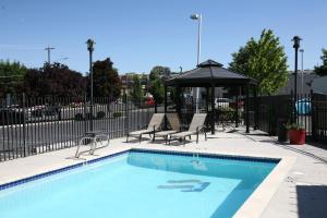 una piscina con due sedie e un ombrellone di Inn America - Lewiston a Lewiston