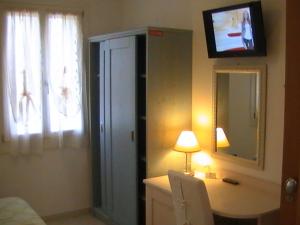 Dormitorio con tocador con espejo y TV en Agriturismo Dolceacqua, en Cavallino-Treporti