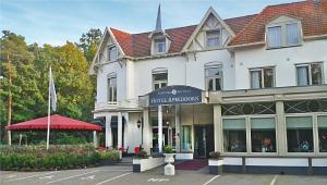 un grande edificio bianco con un cartello per un negozio di Fletcher Hotel Apeldoorn ad Apeldoorn