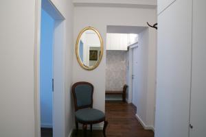 a hallway with a mirror and a chair at 3 Bridges App in Ljubljana