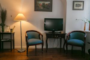 a living room with two chairs and a television at 3 Bridges App in Ljubljana