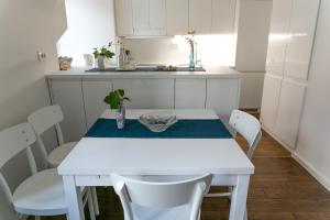 a kitchen with a white table and white chairs at 3 Bridges App in Ljubljana