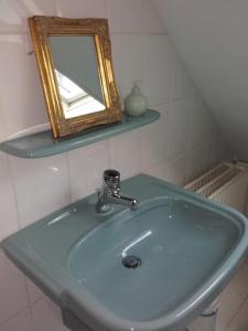 bagno con lavandino verde e specchio di De Oude Smederij a Noord-Sleen