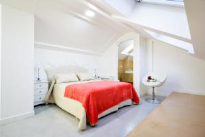 een witte slaapkamer met een bed met een rode deken bij Rueiro 17 in A Coruña