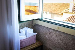 ein Fenster mit einem Korb Handtücher neben einem Fenster in der Unterkunft Casa Pires Mateus in Monsanto