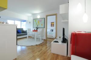 uma sala de estar com um sofá e uma mesa com uma mala vermelha em White Dream Suites em Iaşi