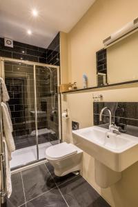 a bathroom with a toilet and a sink and a shower at Jerichos Boutique Accommodation in Windermere