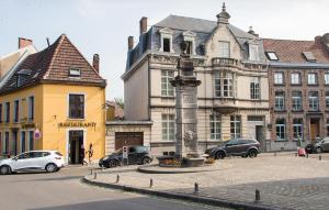 a street with cars parked in front of a building at Hotel Saint Georges in Mons