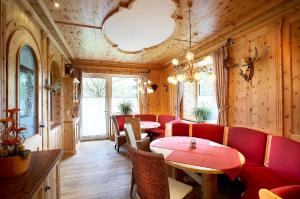 un restaurant avec des chaises et des tables rouges dans une salle dans l'établissement Hotel Wieser, à Mittersill