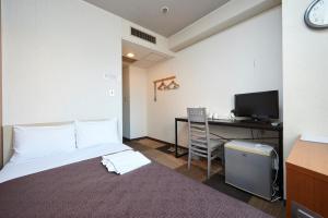 Camera con letto e scrivania con computer. di Hotel Select Inn Utsunomiya a Utsunomiya