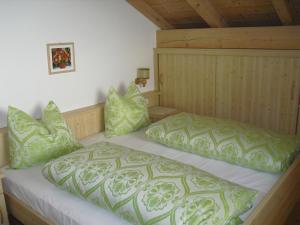 een slaapkamer met een bed met groene kussens bij Oberpapping in San Candido