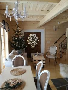 ein Wohnzimmer mit einem Weihnachtsbaum, einem Tisch und Stühlen in der Unterkunft Domki Pasja II 2,5 km do wyciągu naciarskiego Czorsztyn Ski in Kluszkowce