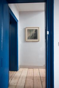 une porte bleue menant à une pièce ornée d'un tableau dans l'établissement B&B Villa 36, à Bruxelles