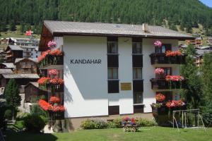 ein Hotel in den Bergen mit Blumen in den Fenstern in der Unterkunft Haus Kandahar in Saas-Fee