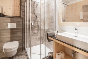 a bathroom with a shower and a toilet and a sink at Apart Gamper in Längenfeld