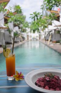 un piatto di cibo e un drink accanto alla piscina di Jali Resort - Gili Trawangan a Gili Trawangan