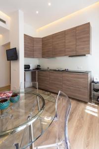 a kitchen with a glass table and wooden cabinets at Le Dimore del Conte in Vicenza