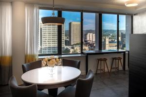 une salle à manger avec une table, des chaises et une grande fenêtre dans l'établissement Suite 11 Victoria Square, à Adélaïde