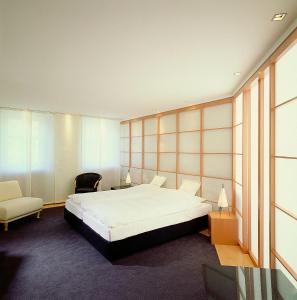 a bedroom with a large bed and a chair at Hotel Goldener Karpfen OHG in Fulda