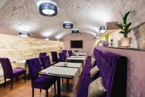 uma sala de jantar com cadeiras e mesas roxas em Hotel Natalia 18 em Lviv