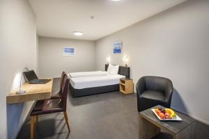 Aparthotel-aarau-WEST Swiss Quality في Oberentfelden: غرفه فندقيه بسرير ومكتب وكرسي