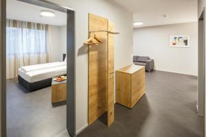 Aparthotel-aarau-WEST Swiss Quality في Oberentfelden: غرفه فندقيه سرير ودولاب