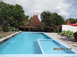 日惹Alam Jogja Resort Mitra RedDoorz的一座房子后院的游泳池