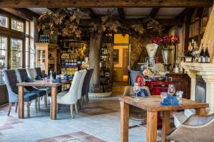 un restaurant avec des tables et des chaises en bois et une cheminée dans l'établissement Bonato Hotel, à Náchod