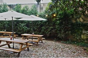 2 mesas de picnic con sombrilla en el patio en Porto Spot Hostel, en Oporto