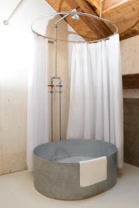 a bath tub in a room with a shower at Alter Schlachthof in Bressanone