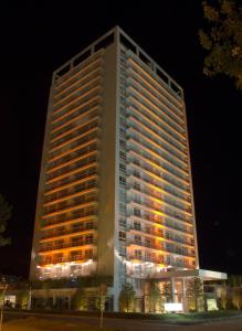 un edificio alto con luces encendidas por la noche en Yoo Punta del Este - Rental Club Apartments, en Punta del Este