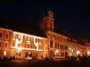 ein großes Gebäude mit einem Uhrturm in der Nacht in der Unterkunft Hotel Barbarossa in Cheb