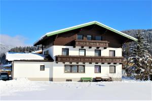 ein großes Gebäude mit Schnee davor in der Unterkunft Alpenzeit in Flachau