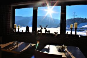 ein Restaurant mit zwei Hirschstatuen vor einem Fenster in der Unterkunft Alpenzeit in Flachau