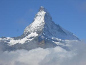 een berg die uit de lucht steekt boven de wolken bij Chalet Kolibri in Zermatt