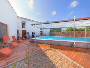 ein Haus mit einem Pool auf einer Holzterrasse in der Unterkunft SEETELHOTEL Nautic Usedom Hotel & Spa in Ostseebad Koserow