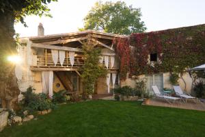 a house with two chairs in the yard at La Tillaie SPA et Sauna in Pont-lʼAbbé-dʼArnoult