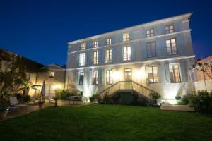 a large building with a lawn in front of it at La Tillaie SPA et Sauna in Pont-lʼAbbé-dʼArnoult