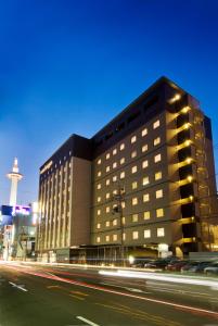 a building on a city street at night at Dormy Inn Premium Kyoto Ekimae Natural Hot Spring in Kyoto