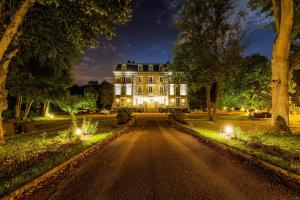 una casa grande con luces en una carretera en Logis Hôtel & Restaurant - Le Manoir de Sauvegrain, en Saint-Lambert