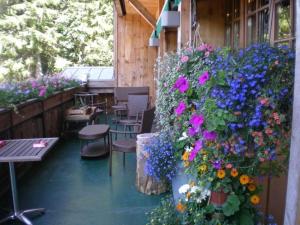 - une terrasse avec un bouquet de fleurs, des tables et des chaises dans l'établissement Chalet Hotel Le Collet, à Xonrupt-Longemer